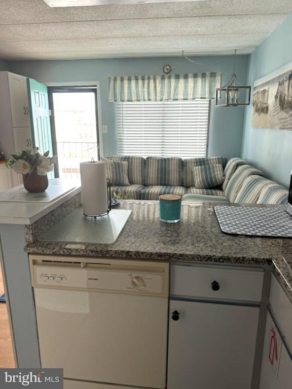 504 E 17th Ave Unit 206, Wildwood, NJ 08260 - kitchen featuring an inviting chandelier, white dishwasher, dark stone counters, and a textured ceiling