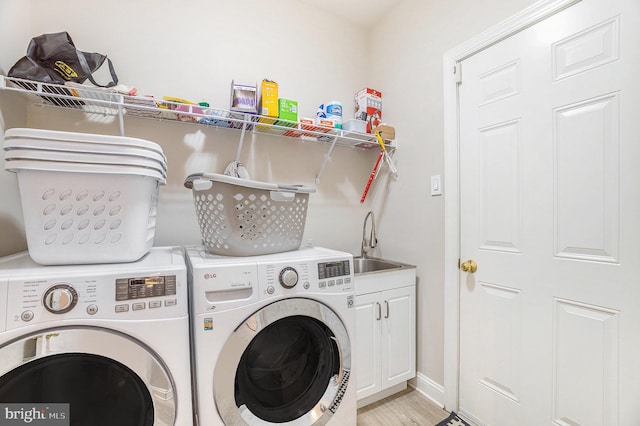 33 Brownstone Dr, East Norriton, PA 19401 - clothes washing area with a sink, washing machine and dryer, light wood-type flooring, baseboards, and cabinet space