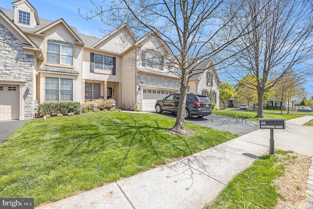 33 Brownstone Dr, East Norriton, PA 19401 - view of property with stucco siding, stone siding, a front yard, and aphalt driveway
