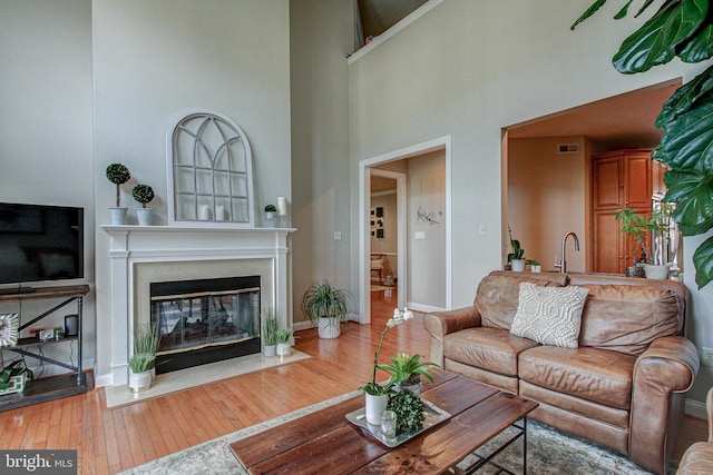 33 Brownstone Dr, East Norriton, PA 19401 - living area with hardwood / wood-style floors, a towering ceiling, visible vents, baseboards, and a fireplace