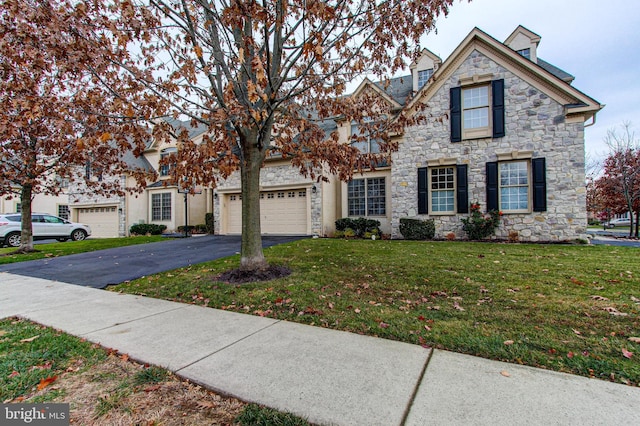 33 Brownstone Dr, East Norriton, PA 19401 - view of front of house featuring stone siding, an attached garage, aphalt driveway, and a front yard
