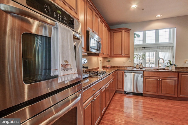33 Brownstone Dr, East Norriton, PA 19401 - kitchen featuring stainless steel appliances, a sink, dark stone counters, recessed lighting, and brown cabinetry
