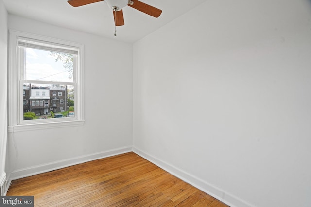 empty room with light wood finished floors, baseboards, and ceiling fan