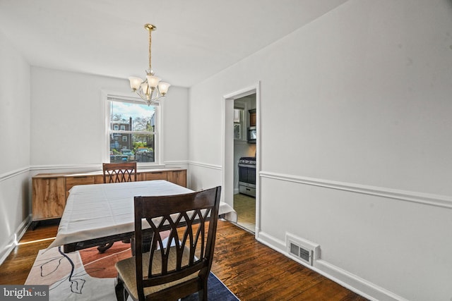 dining room featuring baseboards, visible vents, a chandelier, and dark wood-style flooring