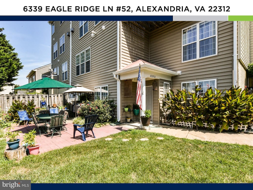 exterior space featuring a patio, a front lawn, and fence