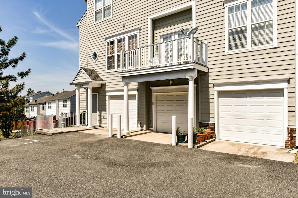 view of front of property with fence, a balcony, and a garage