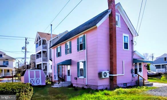 6261 Post Office St, Chincoteague Island, VA 23336 - back of property with crawl space, an outdoor structure, ac unit, and a storage unit