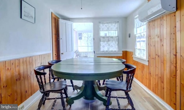 6261 Post Office St, Chincoteague Island, VA 23336 - dining area featuring wood walls, a wainscoted wall, light wood-type flooring, and a wall unit AC