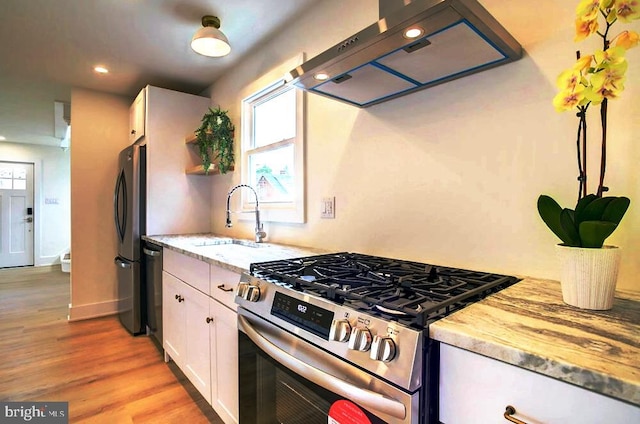 10155 Atlantic Rd, Atlantic, VA 23303 - kitchen with light stone countertops, white cabinetry, under cabinet range hood, a sink, and stainless steel appliances