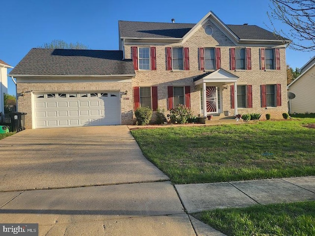colonial home with brick siding, a front yard, an attached garage, and concrete driveway