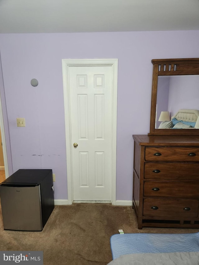 carpeted bedroom featuring baseboards and fridge