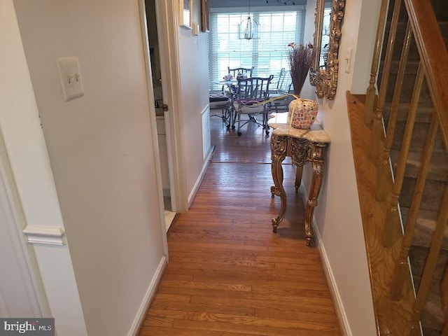 hallway with baseboards and hardwood / wood-style flooring