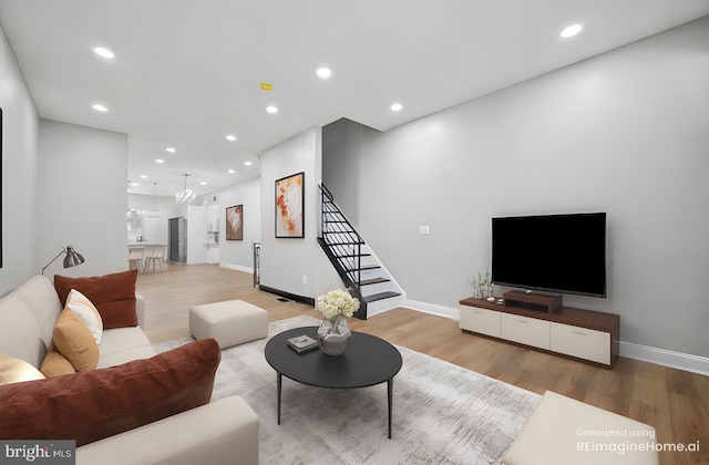 living room with wood finished floors, baseboards, and stairway