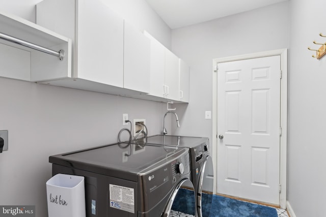 laundry room featuring baseboards, cabinet space, and washer and clothes dryer