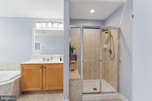 full bath featuring tile patterned floors, a garden tub, vanity, and a stall shower