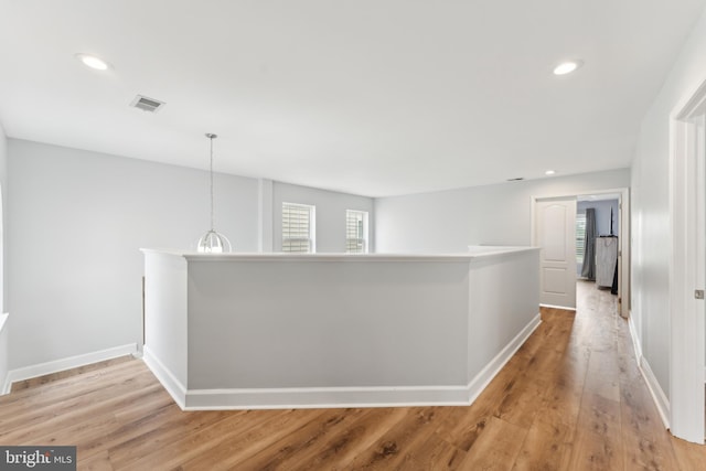 hall featuring recessed lighting, an upstairs landing, visible vents, and light wood-type flooring
