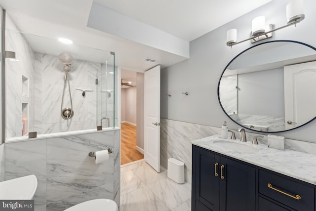 full bathroom featuring marble finish floor, toilet, vanity, a marble finish shower, and tile walls