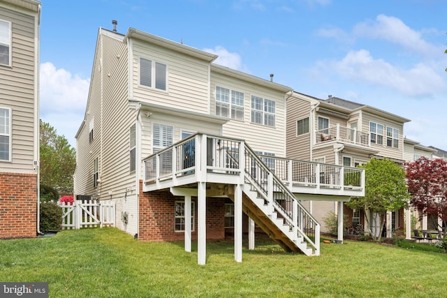 rear view of house featuring stairway, a wooden deck, a gate, and a yard