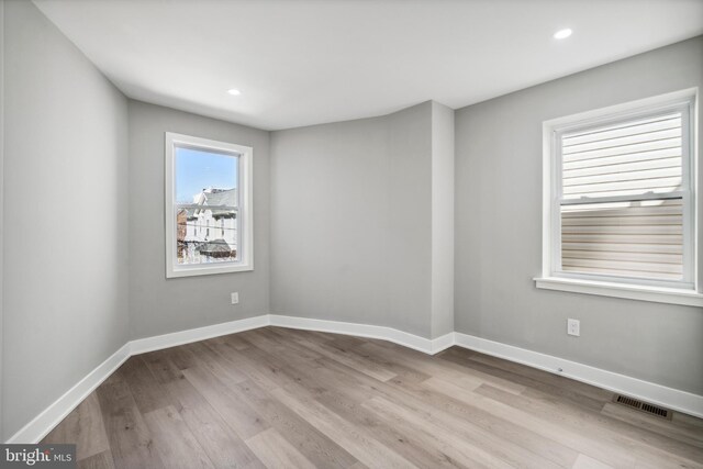 unfurnished room featuring wood finished floors, baseboards, visible vents, and recessed lighting