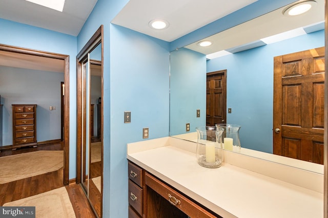 full bathroom with vanity, recessed lighting, and wood finished floors