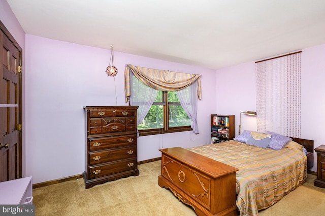 bedroom with baseboards and light colored carpet