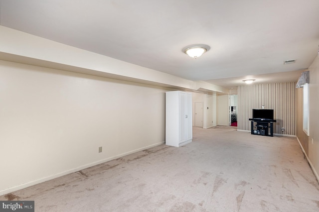 basement featuring baseboards and light carpet