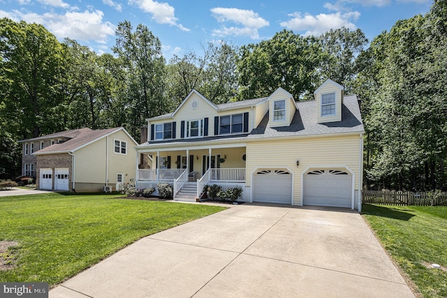 colonial home featuring covered porch, fence, driveway, and a front lawn