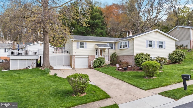 raised ranch featuring brick siding, a front lawn, driveway, and a garage