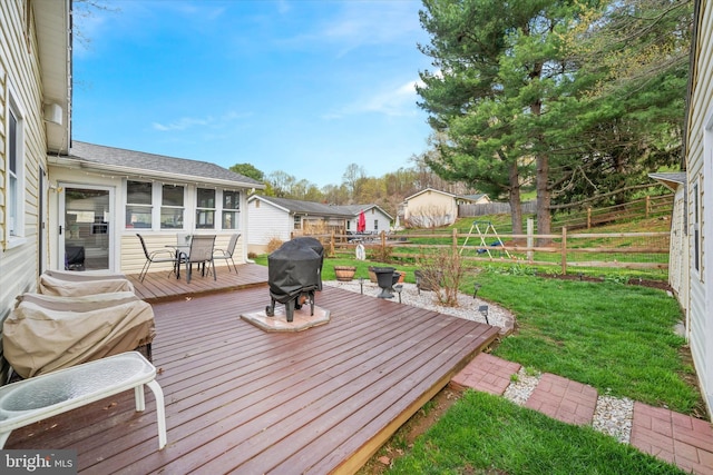 wooden deck featuring a fenced backyard, a yard, and area for grilling