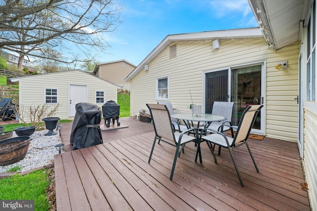 wooden deck featuring an outbuilding and outdoor dining space