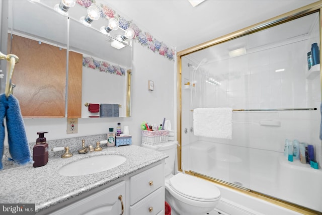 bathroom with vanity, a shower with shower door, and toilet