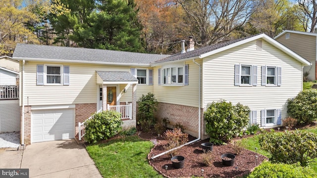 split foyer home with brick siding, roof with shingles, concrete driveway, and a garage