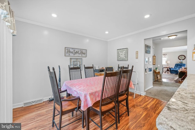 dining room with ornamental molding, wood finished floors, visible vents, and recessed lighting