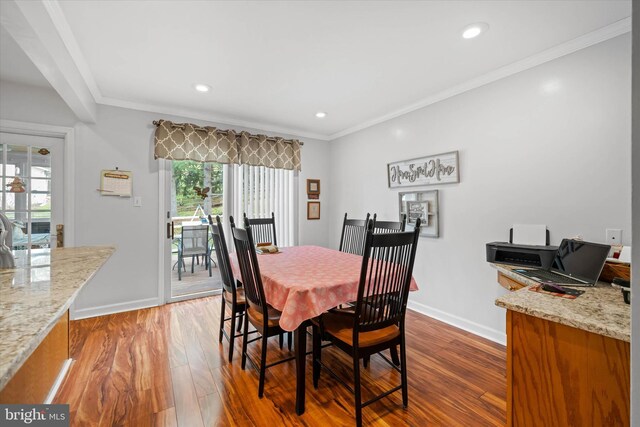 dining room with baseboards, wood finished floors, recessed lighting, and crown molding