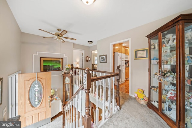 hallway with an upstairs landing and carpet