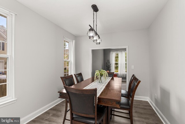 dining space with dark wood-style flooring and baseboards