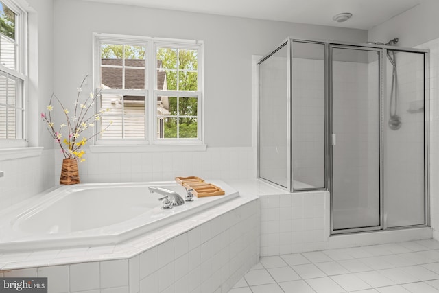 bathroom with tile patterned flooring, a shower stall, and a bath