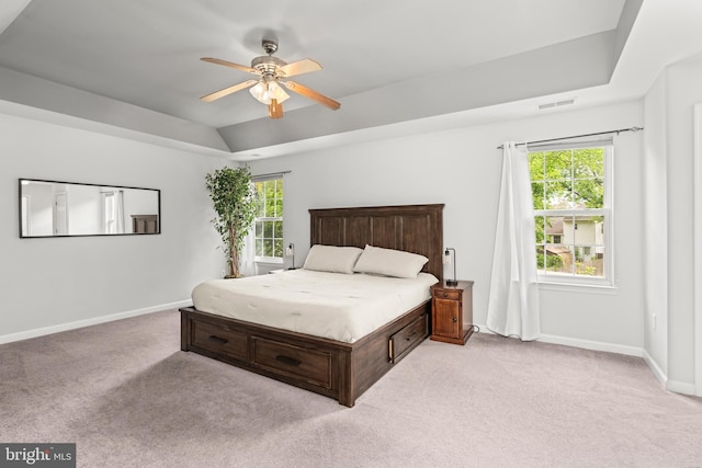 bedroom featuring light colored carpet, multiple windows, and baseboards