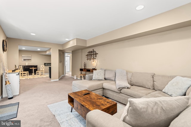 living area with light carpet, recessed lighting, and baseboards