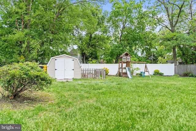 view of yard with a playground, a storage unit, and an outbuilding