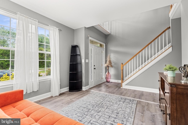 foyer featuring stairway, wood finished floors, and baseboards