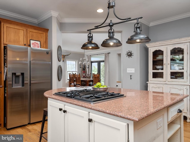 kitchen featuring light wood-style floors, ornamental molding, a kitchen island, and stainless steel appliances