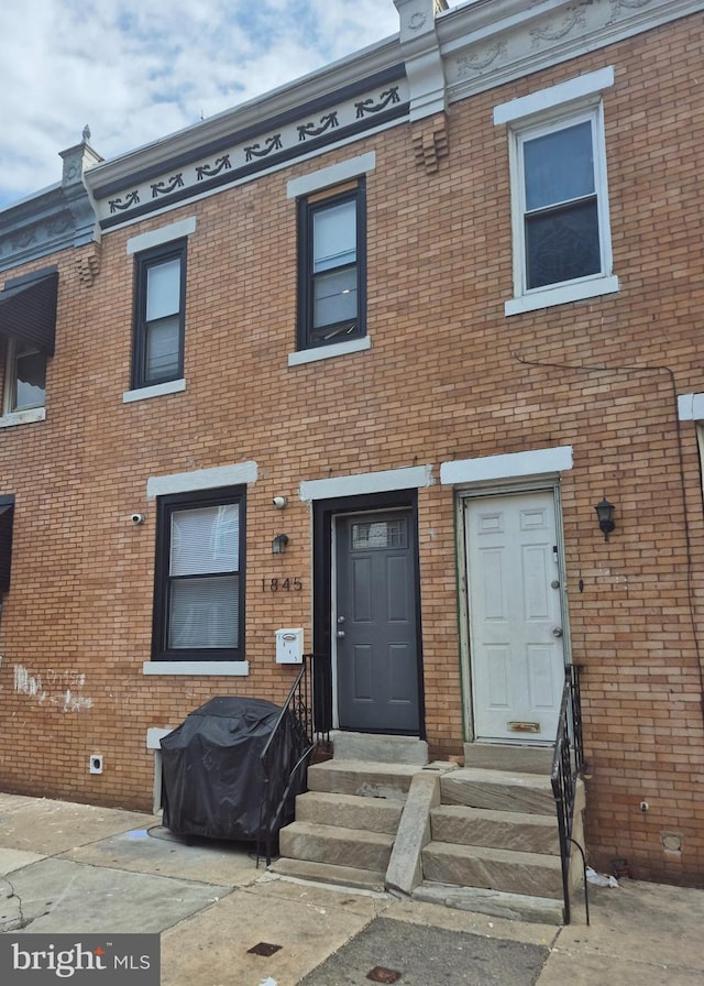 multi unit property featuring entry steps and brick siding