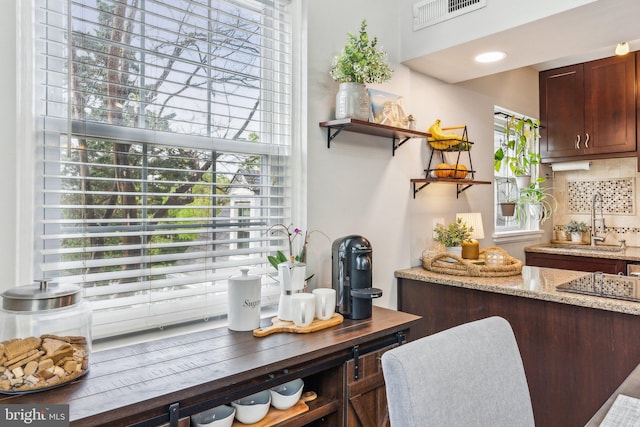 bar with backsplash, a sink, and visible vents