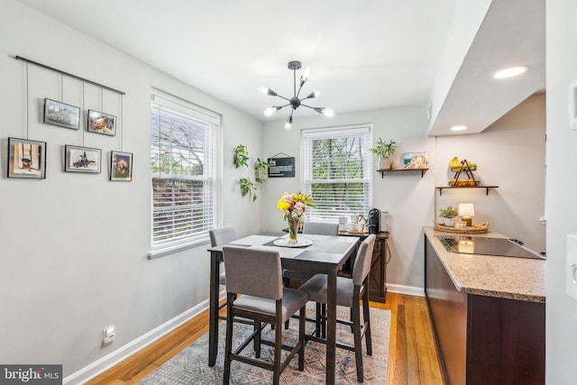 dining room with baseboards, a notable chandelier, light wood-style floors, and recessed lighting