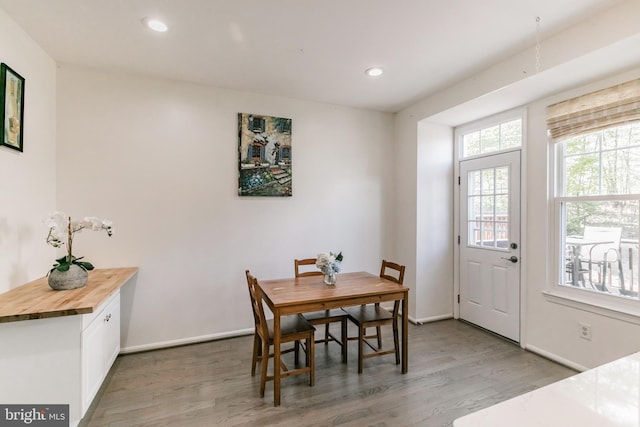 dining area with baseboards, wood finished floors, and recessed lighting