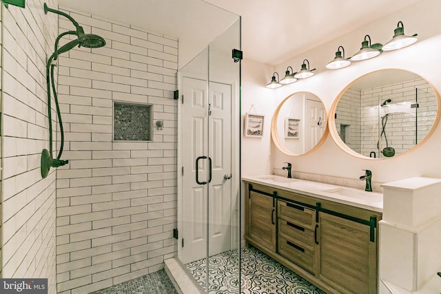 full bath featuring tile patterned flooring, a sink, double vanity, and a stall shower