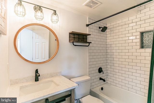 bathroom featuring visible vents, toilet, vanity, and shower / tub combination