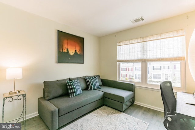home office featuring baseboards, wood finished floors, and visible vents