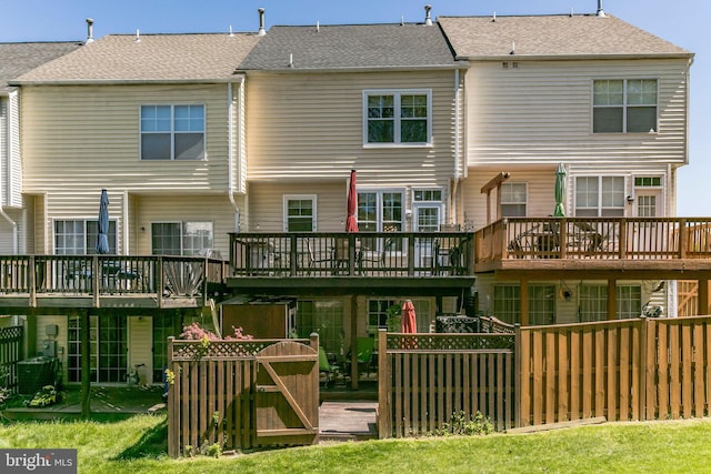 rear view of house featuring a wooden deck and a shingled roof